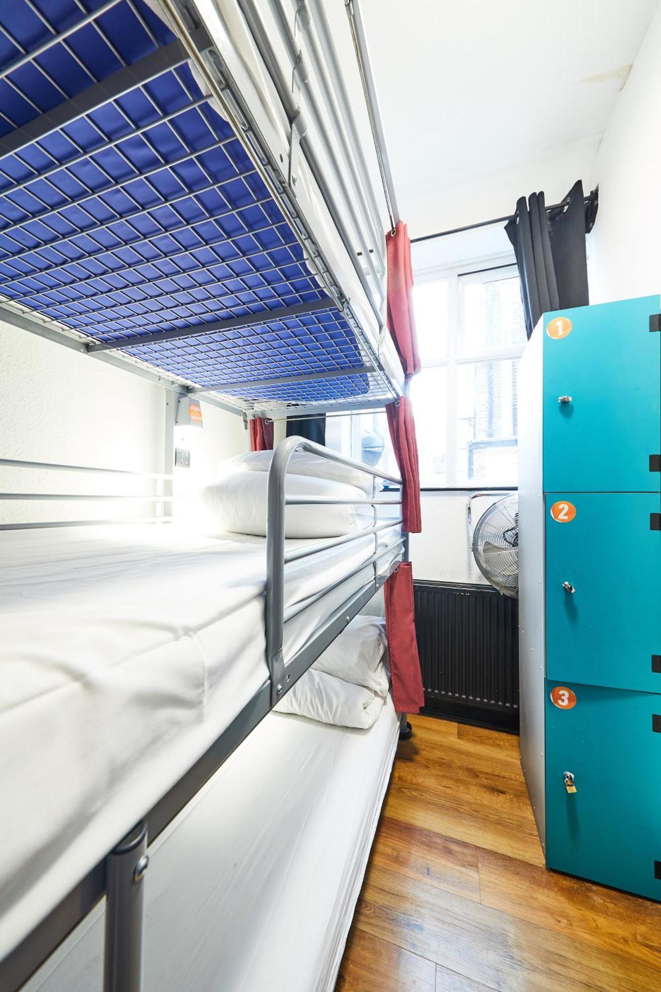 Cama en habitación compartida mixta con 12 camas y baño compartido